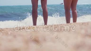 男人和女人站在海边的海滩上。 一对夫妇站在海滨，脚上沾满了水。 夏季和
